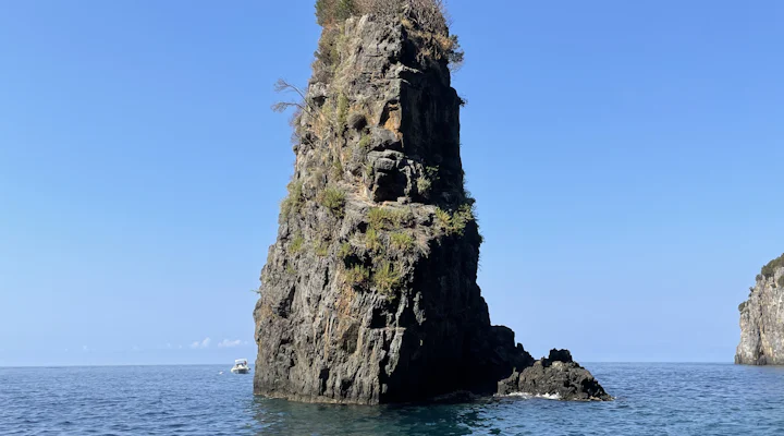 Faraglione roccioso che emerge dal mare blu della costa di Palinuro
